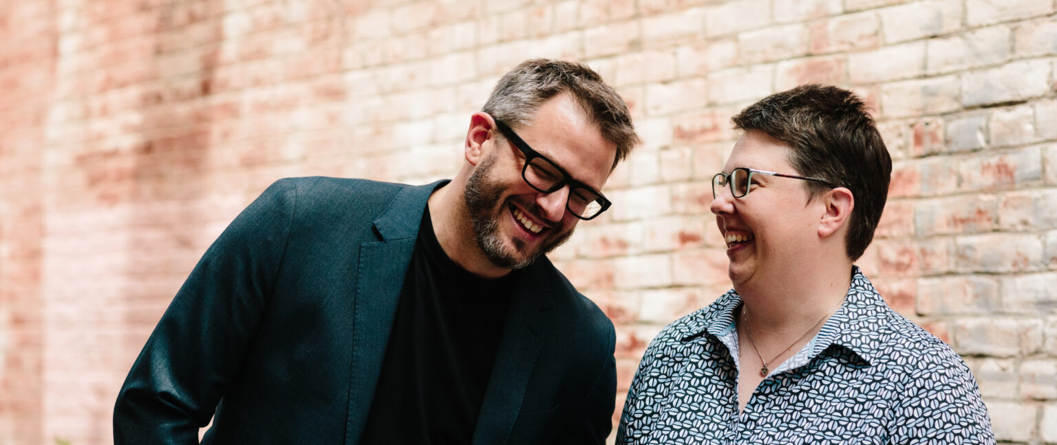 Jason Berg and Mel Miller laughing together in Crane Alley in Urbana.